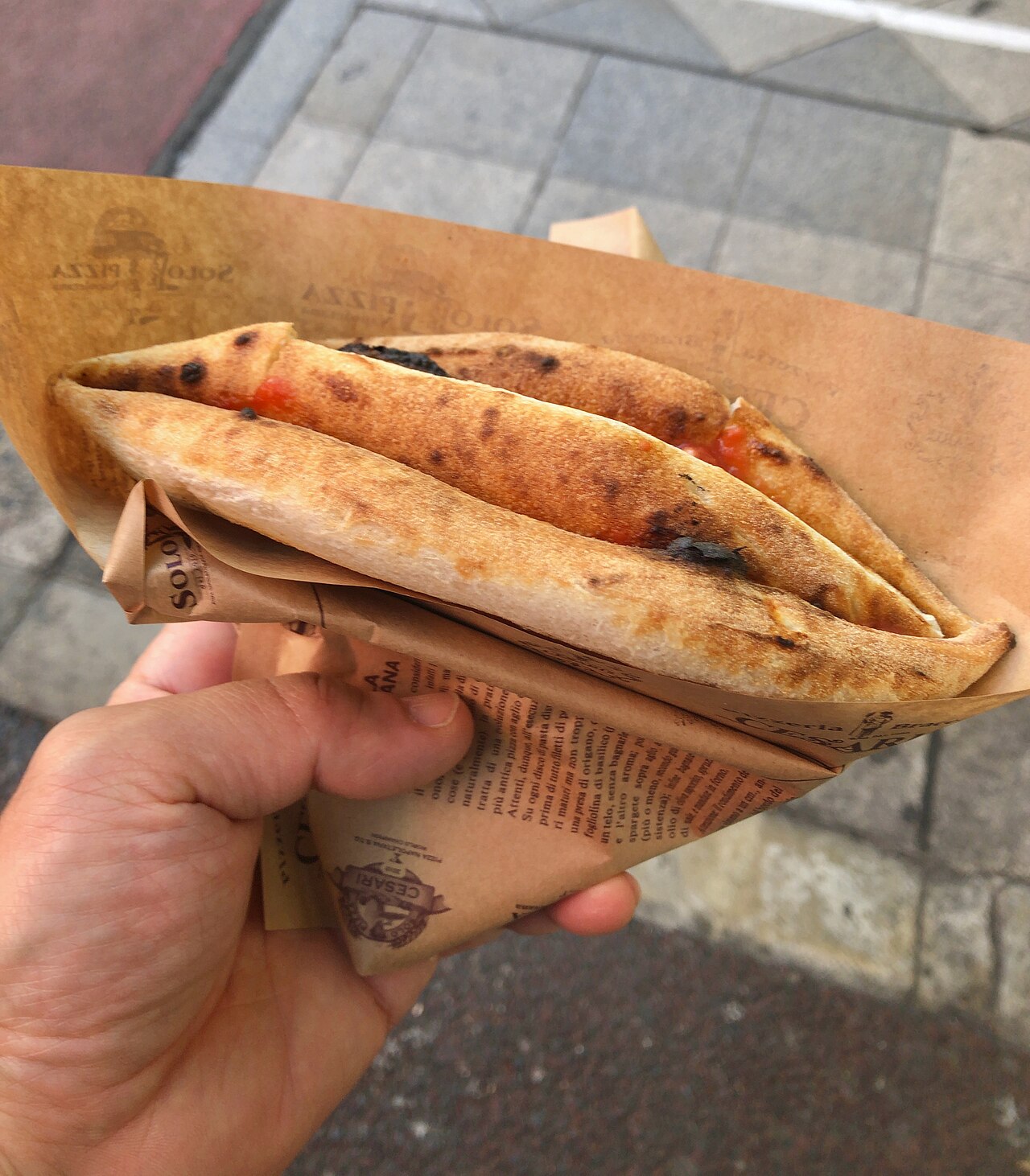 Pizza a portafoglio piegata in quattro nella carta